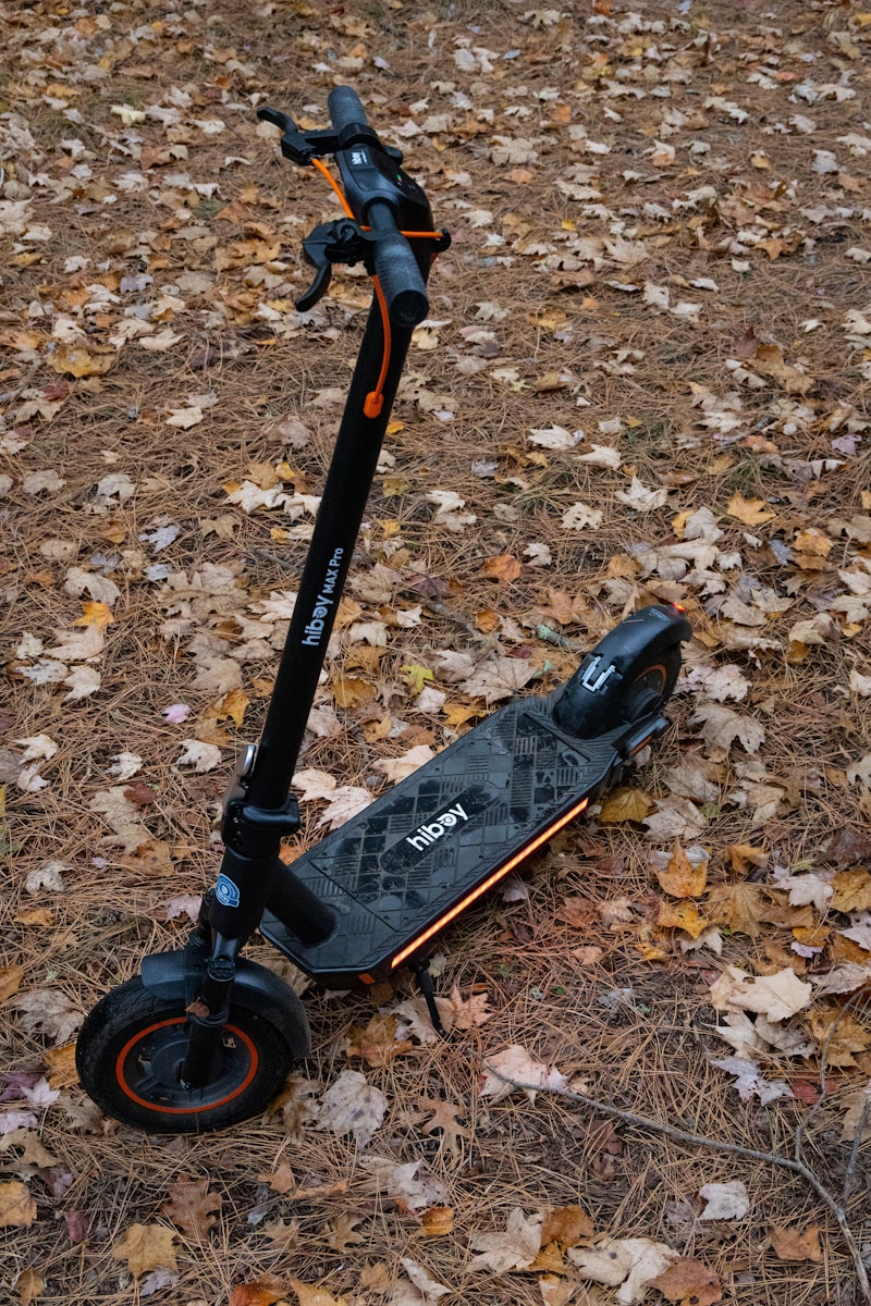 A scooter is sitting in the leaves on the ground